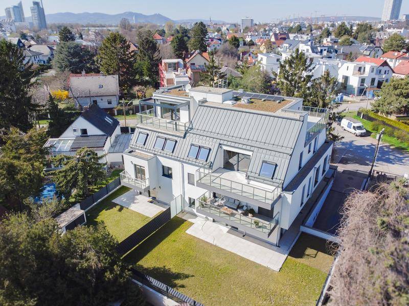 Moderne Wohnanlage mit gepflegtem Gartenbereich und Blick auf die umliegende Nachbarschaft.