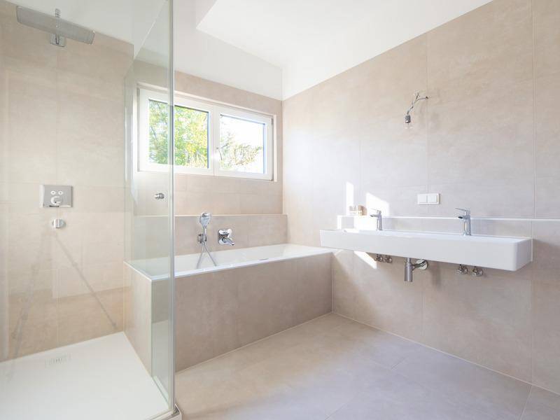 Helles modernes Badezimmer mit Badewanne, ebenerdiger Dusche und Doppelwaschbecken.