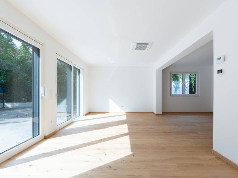Helles Wohnzimmer mit großen Schiebetüren, die viel Tageslicht hereinlassen.