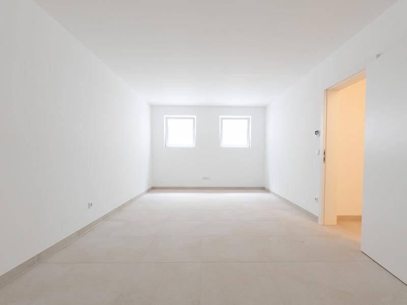 Funktionaler Raum mit Fliesenboden und zwei Fenstern, ideal als Hauswirtschaftsraum.