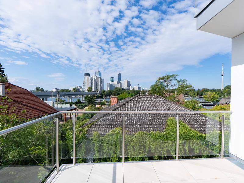 Geräumiger Balkon mit Glasgeländer und beeindruckendem Blick auf die Stadtkulisse.