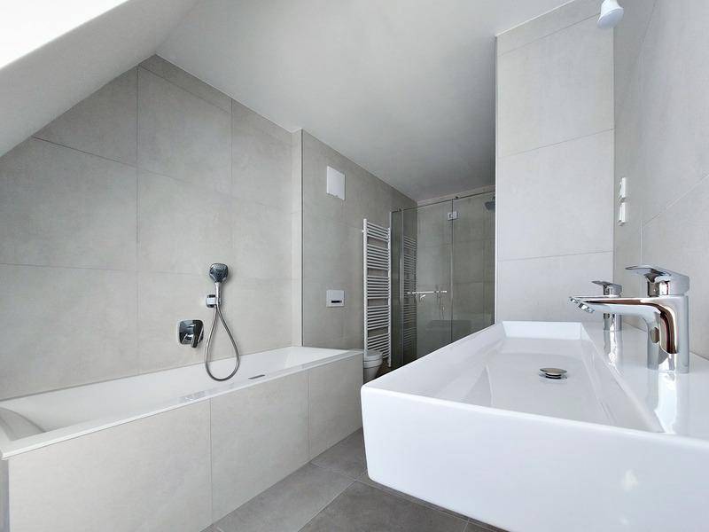 Helles Badezimmer mit Badewanne, modernem Waschbecken und separater Duschkabine.