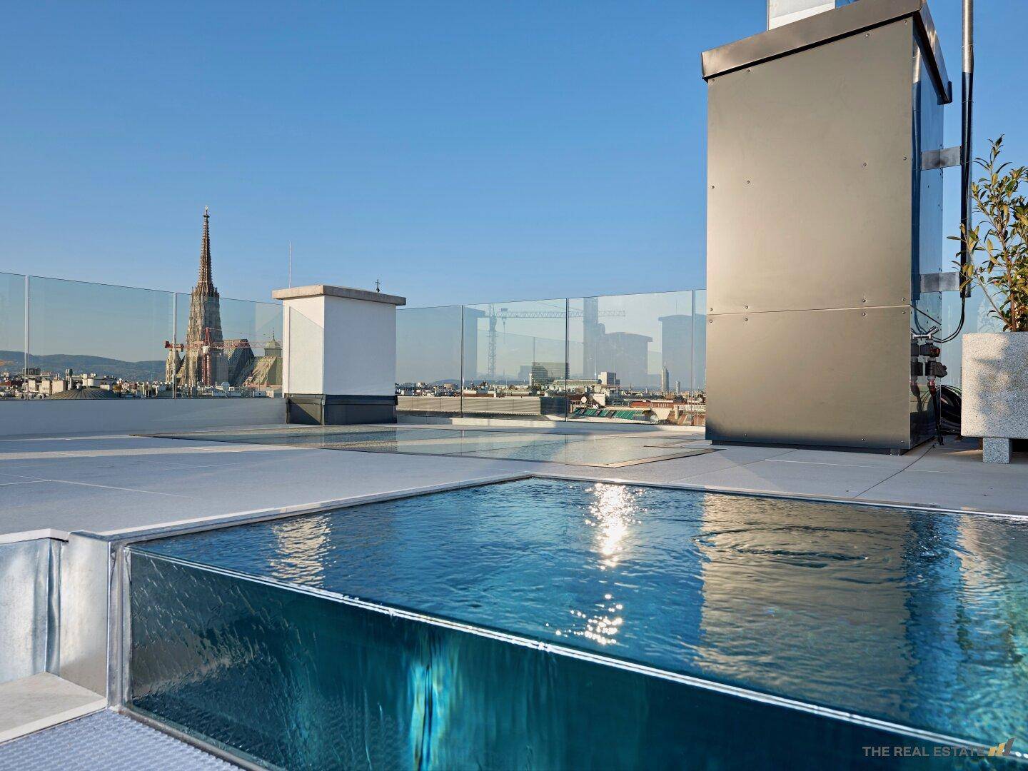 Dachterrasse mit Infinity-Pool und spektakulärem Blick auf die Wiener Skyline und den Stephansdom.