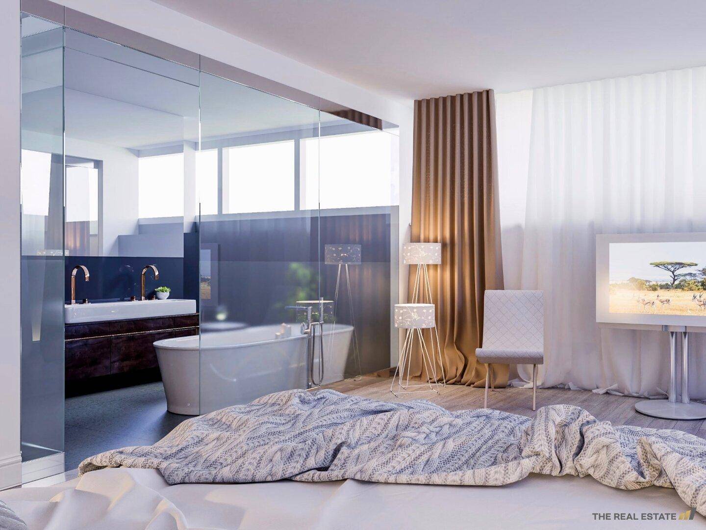 Modernes Schlafzimmer mit offener Badewanne und Glasabtrennung zum Badezimmerbereich.