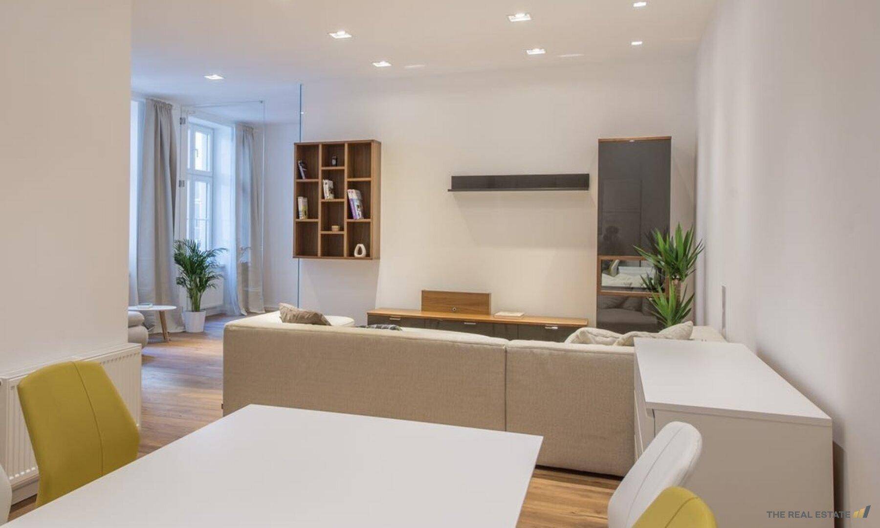 Heller Wohn- und Essbereich mit Holzboden und Blick auf die moderne Küche.