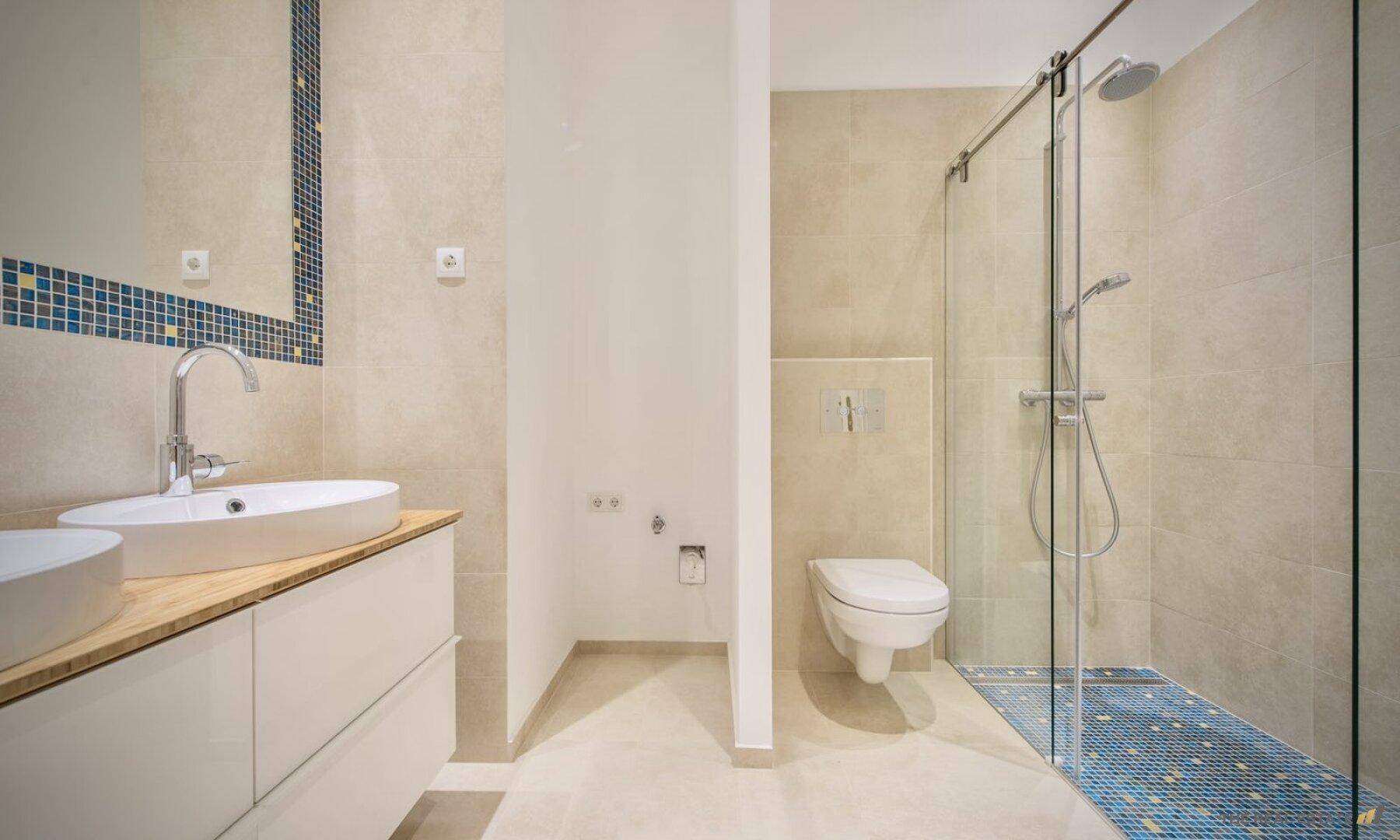 Modernes Badezimmer mit begehbarer Dusche, Doppelwaschbecken und Wand-WC.