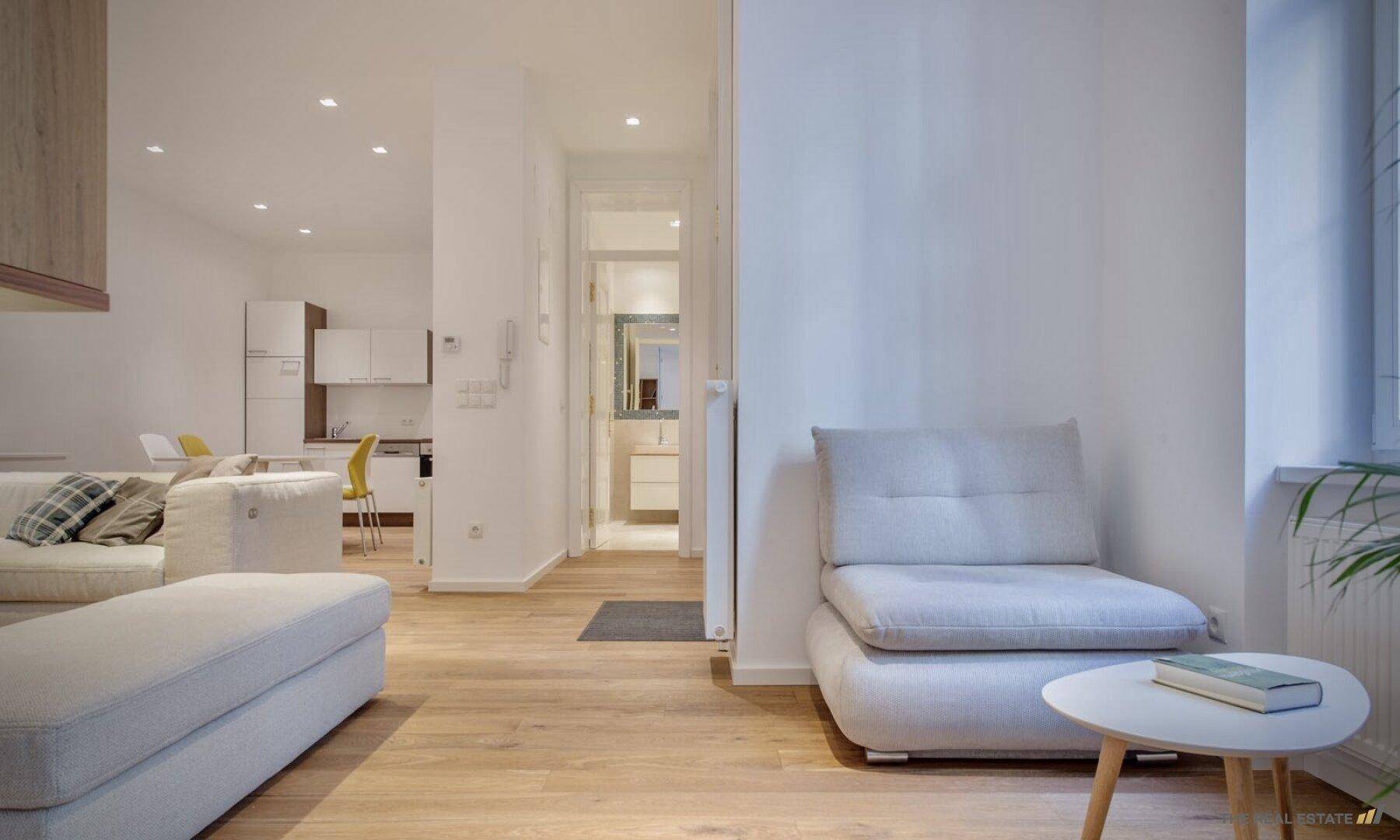 Gemütlicher Wohnbereich mit Holzboden und Blick in den Flur und die angrenzenden Räume.