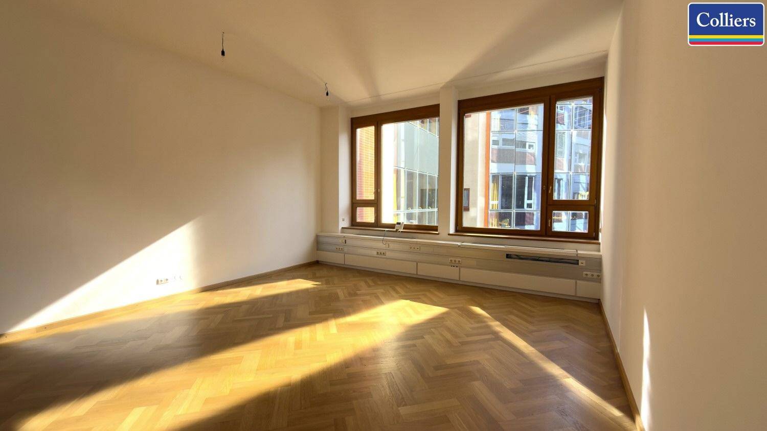 Heller Büroraum mit viel Sonnenlicht und Blick auf die Stadt, ideal für produktives Arbeiten.