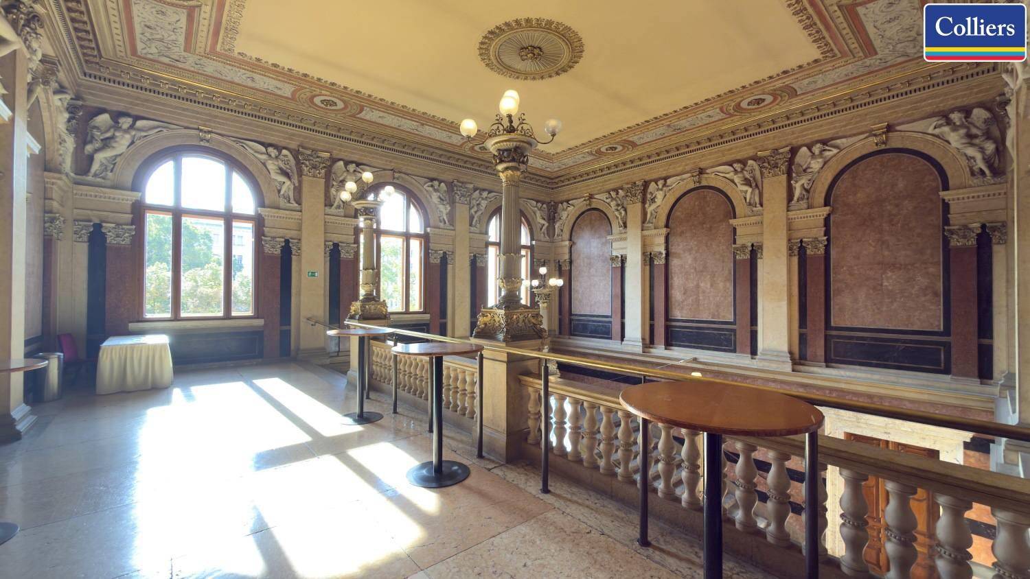 Elegante Galerie im Obergeschoss mit Balustrade, großen Rundbogenfenstern und kunstvollen Verzierungen.