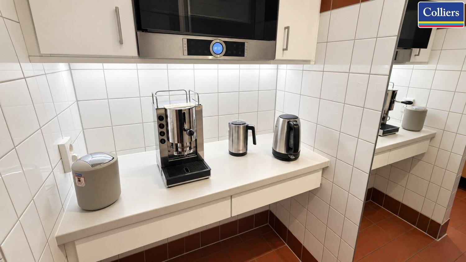 Kleine Küchenzeile mit Kaffeemaschine, Wasserkocher und Mikrowelle, ideal für Pausen.