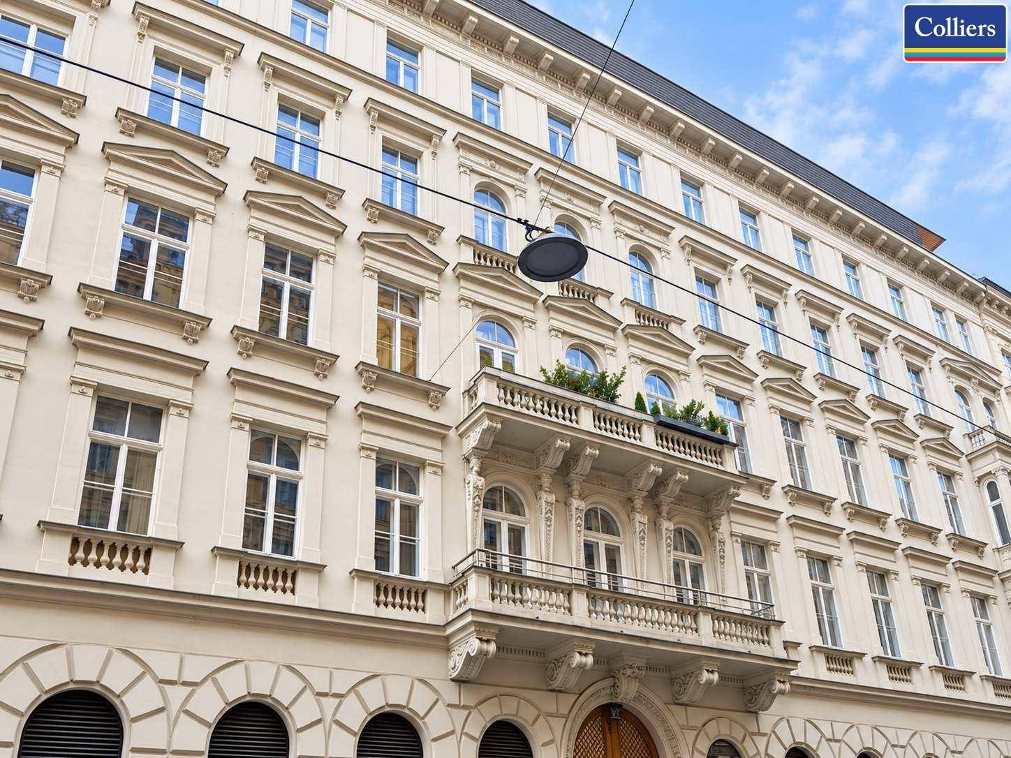Prachtvolle historische Fassade eines Altbaus mit reich verzierten Fenstern und einem zentralen Balkon.