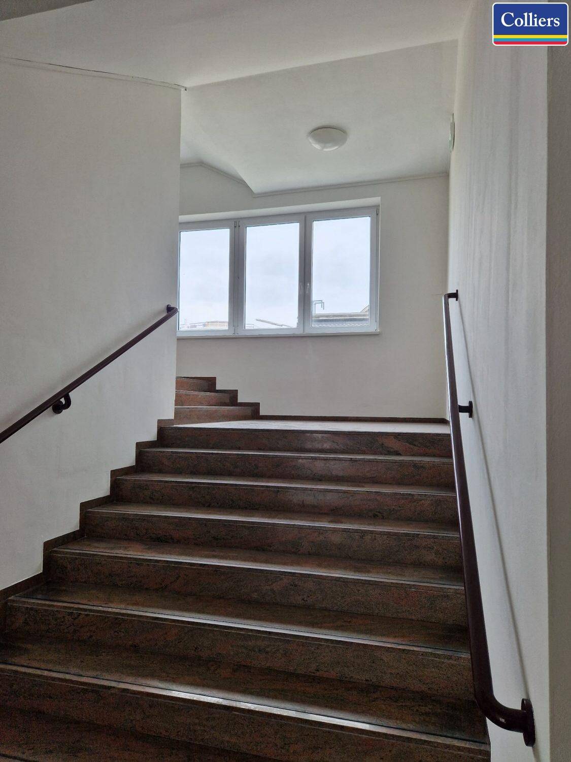 Treppenhaus mit Granitstufen und Handläufen, führt zu den oberen Stockwerken.