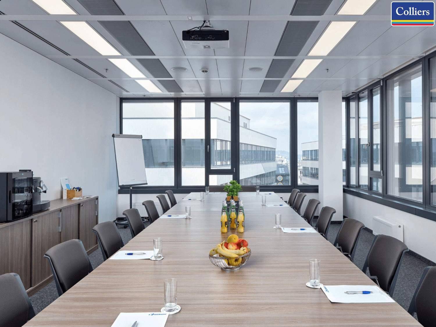 Großer Konferenzraum mit langem Holztisch, vielen Stühlen und weitem Blick durch die Fensterfront.