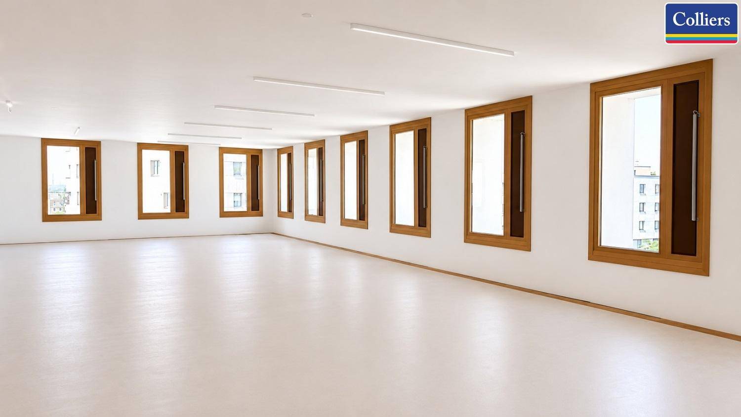 Leerer, heller Büroraum mit vielen Fenstern und minimalistischem Design, bereit zur Einrichtung.