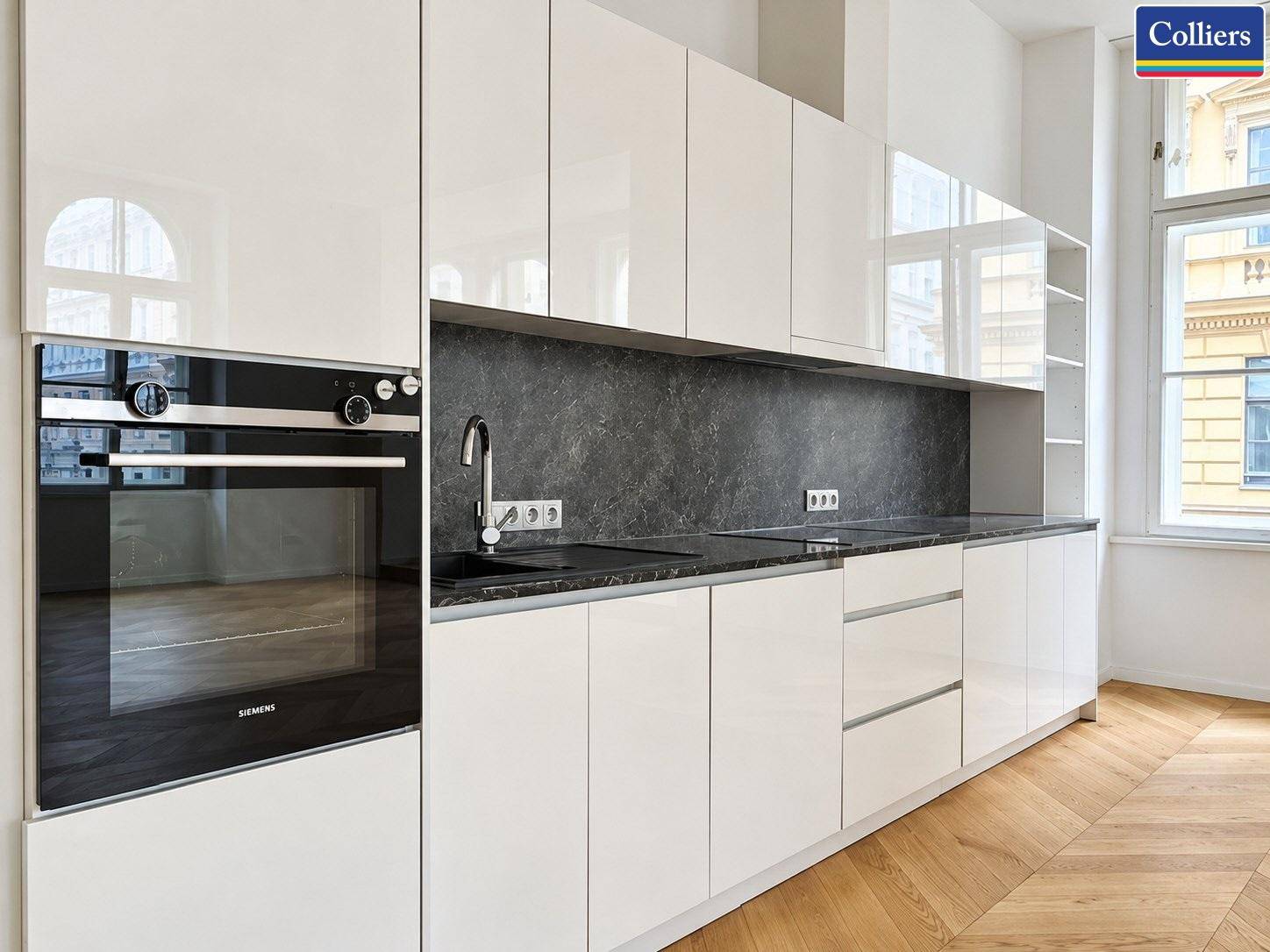 Detailansicht der modernen Einbauküche mit weißen Hochglanzfronten und integriertem Siemens Backofen.