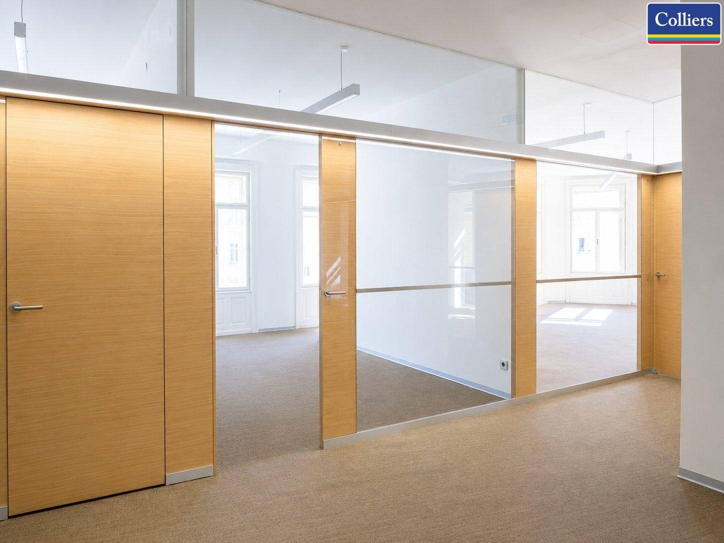 Moderner Bürogang mit Holzverkleidungen und eleganten Glaswänden, die zu den hellen Büroräumen führen.
