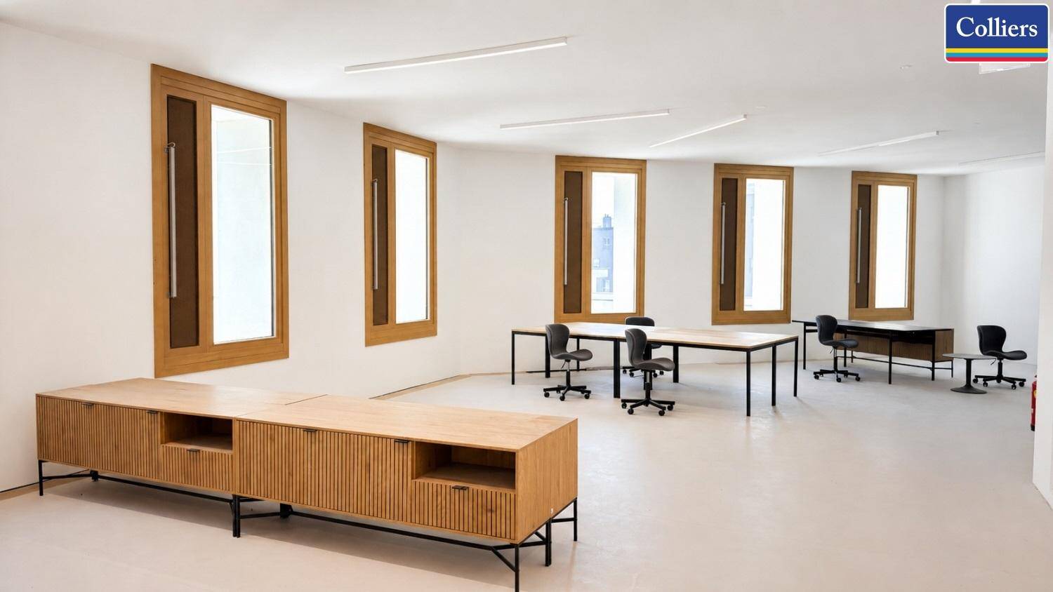 Offener Bürobereich mit modernen Holzschränken, mehreren Schreibtischen und viel natürlichem Licht durch die Fenster.