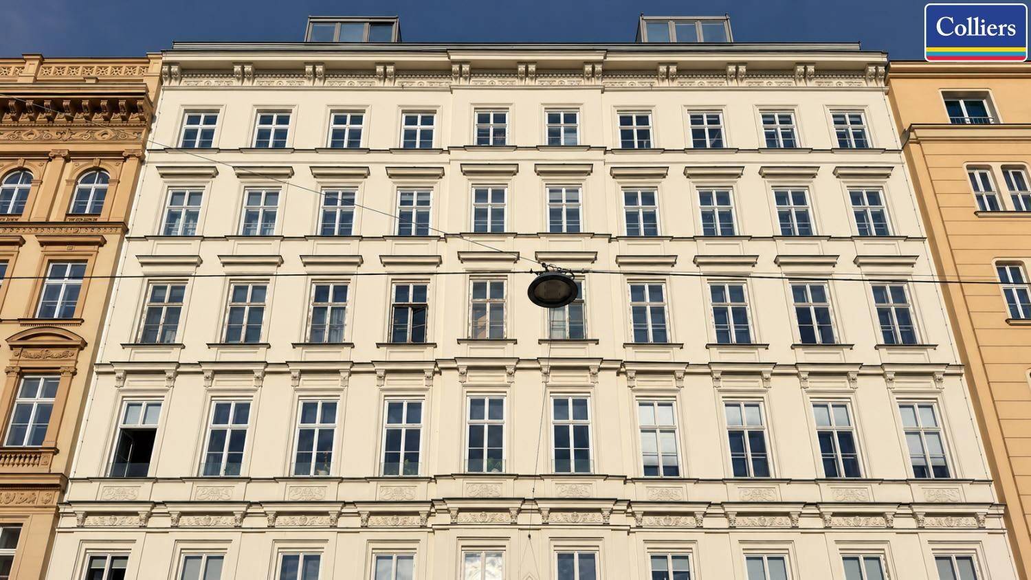 Klassische Fassade eines Mehrfamilienhauses mit vielen Fenstern und traditionellen Verzierungen.