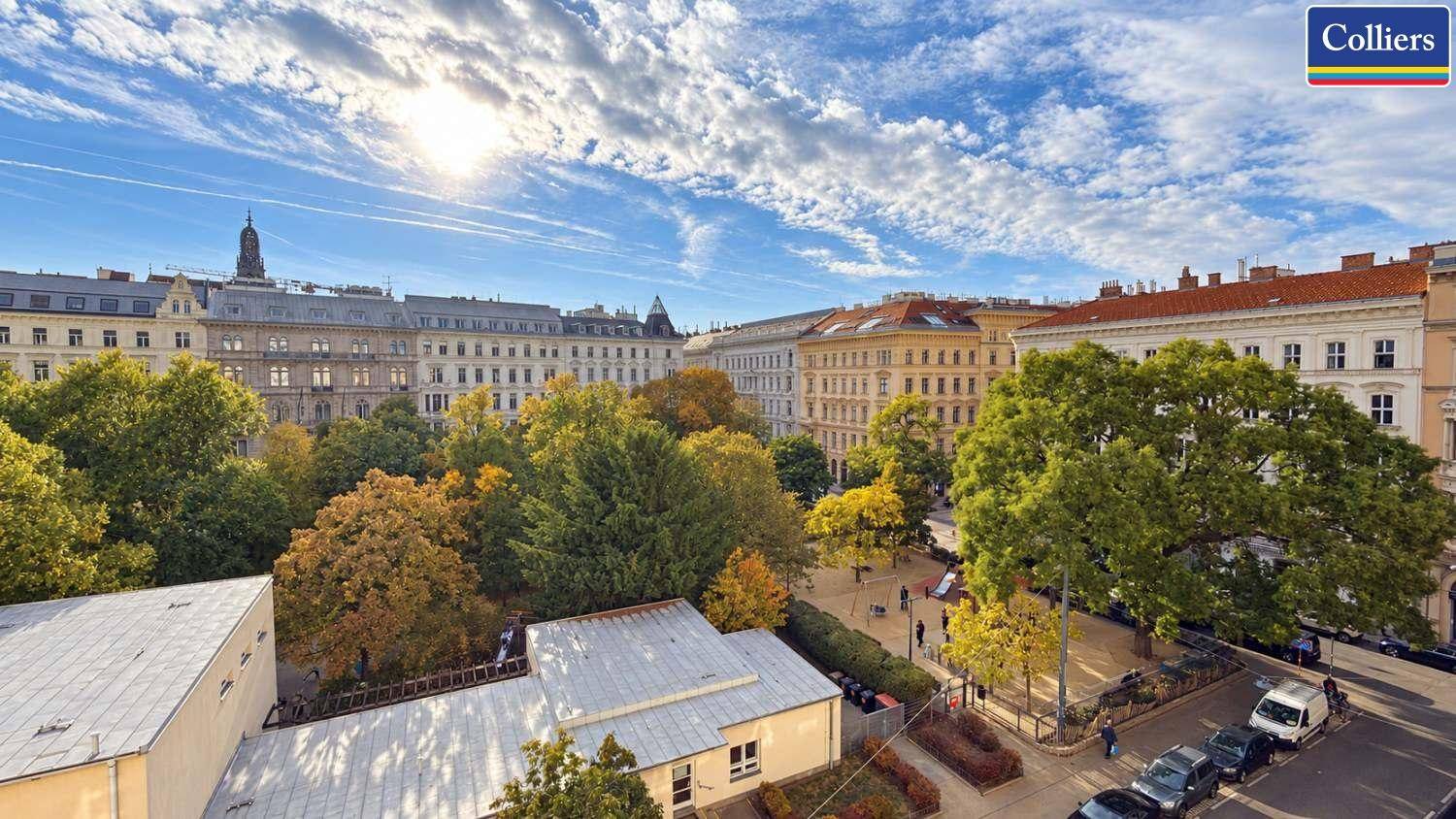Panoramablick über eine grüne Stadtlandschaft mit historischen Gebäuden unter blauem Himmel.