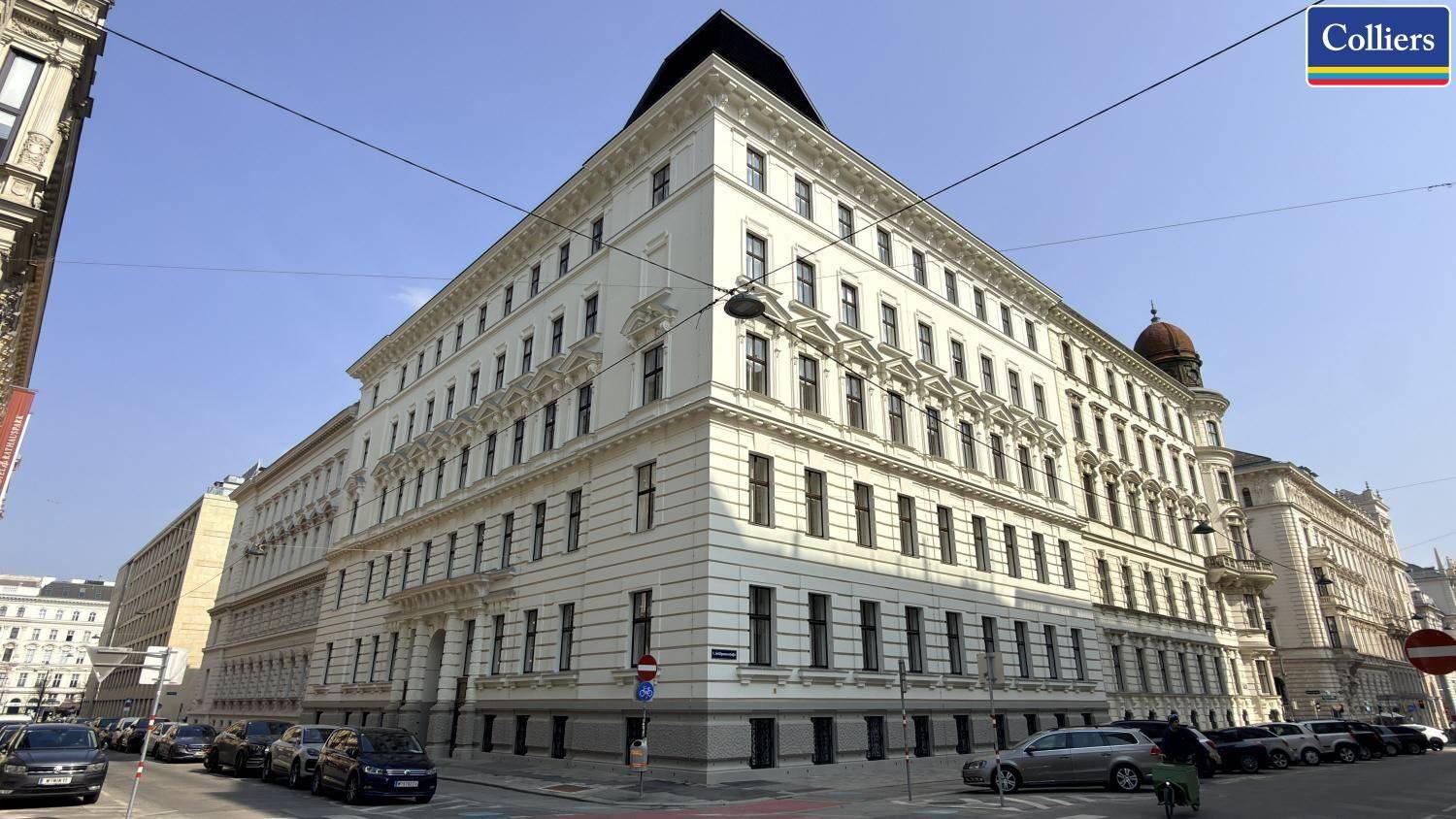 Ein prächtiges Eckgebäude in der Stadt mit klassischer Architektur und vielen Fenstern.