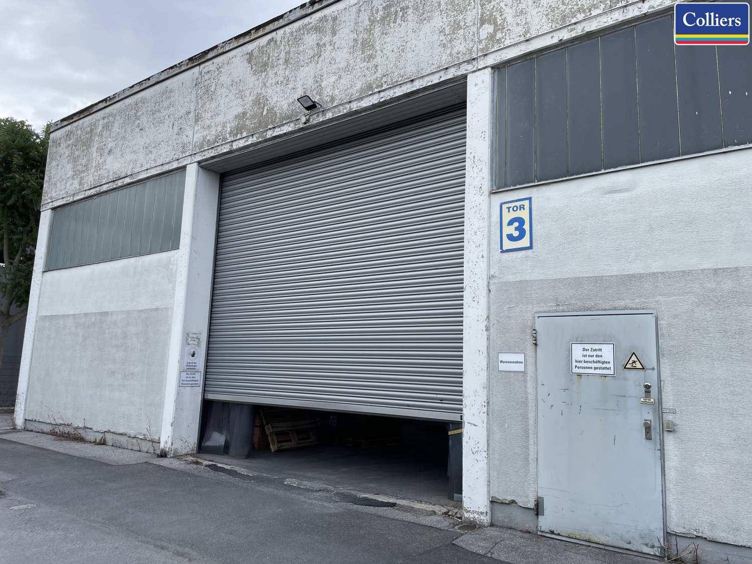 Außenansicht einer Industriehalle mit großem Rolltor Nummer 3 und separatem Eingangsbereich.