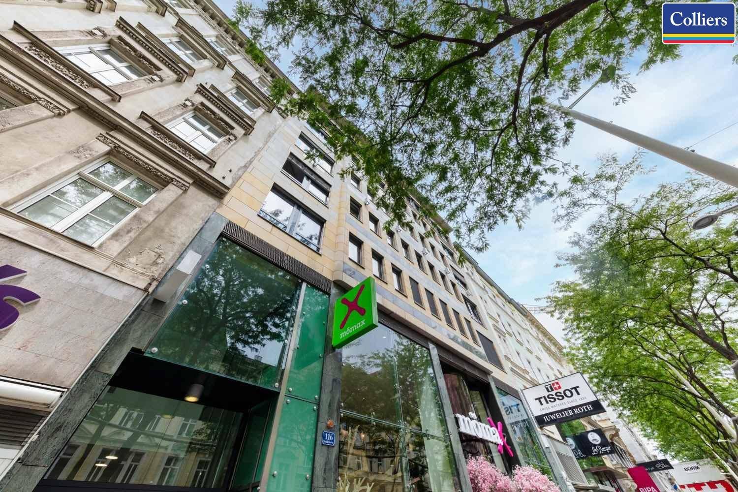 Moderne Geschäftsfassade mit großen Glasflächen und Blick auf die belebte Einkaufsstraße.