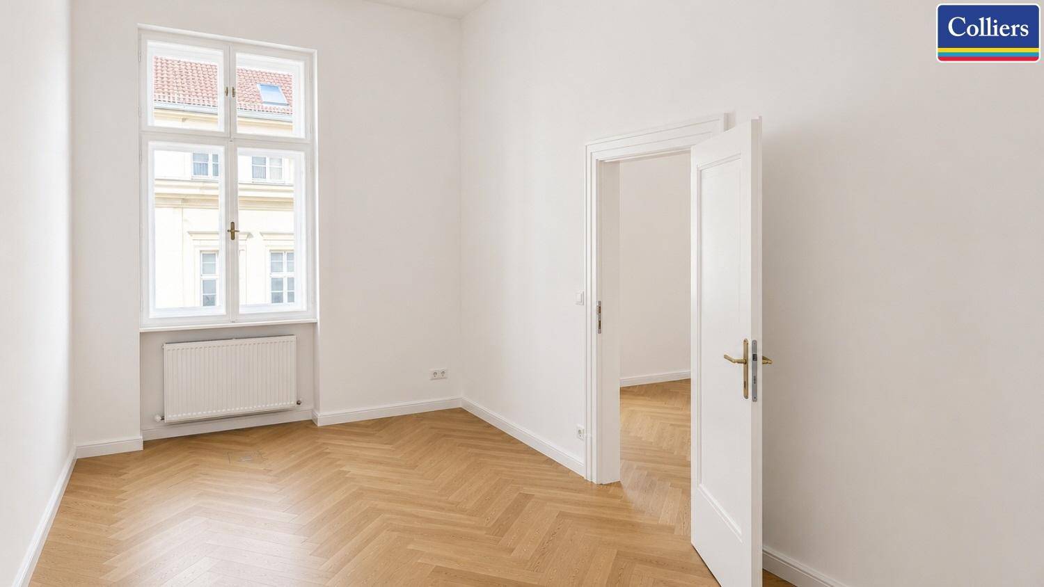 Ruhiges Einzelbüro mit klassischem Fischgrätparkett und einem großen Fenster, das eine angenehme Atmosphäre schafft.