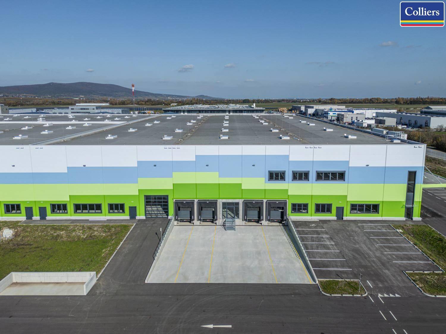 Luftaufnahme einer großen Industrieanlage mit zahlreichen Laderampen und weitläufigen Parkflächen.