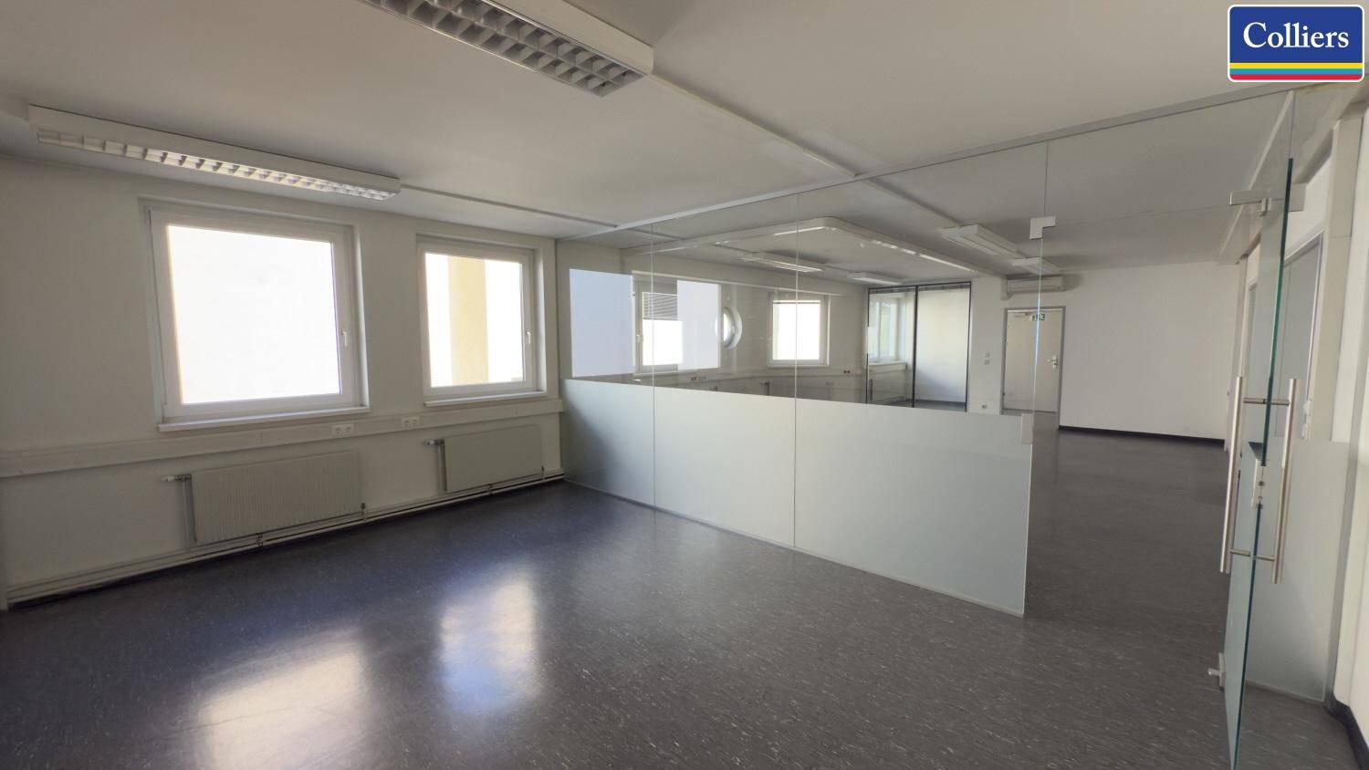 Modernes Büro mit Glaswänden, die separate Arbeitsbereiche schaffen, und viel Tageslicht für eine angenehme Atmosphäre.