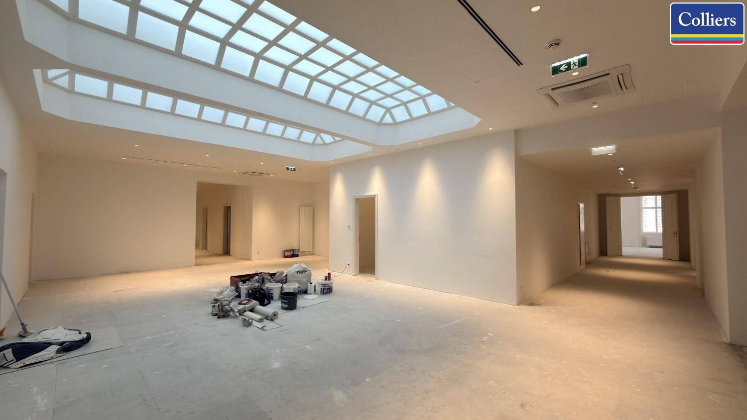 Großer, heller Raum mit beeindruckendem Glasdach und Einbaustrahlern, ideal für ein modernes Büro.