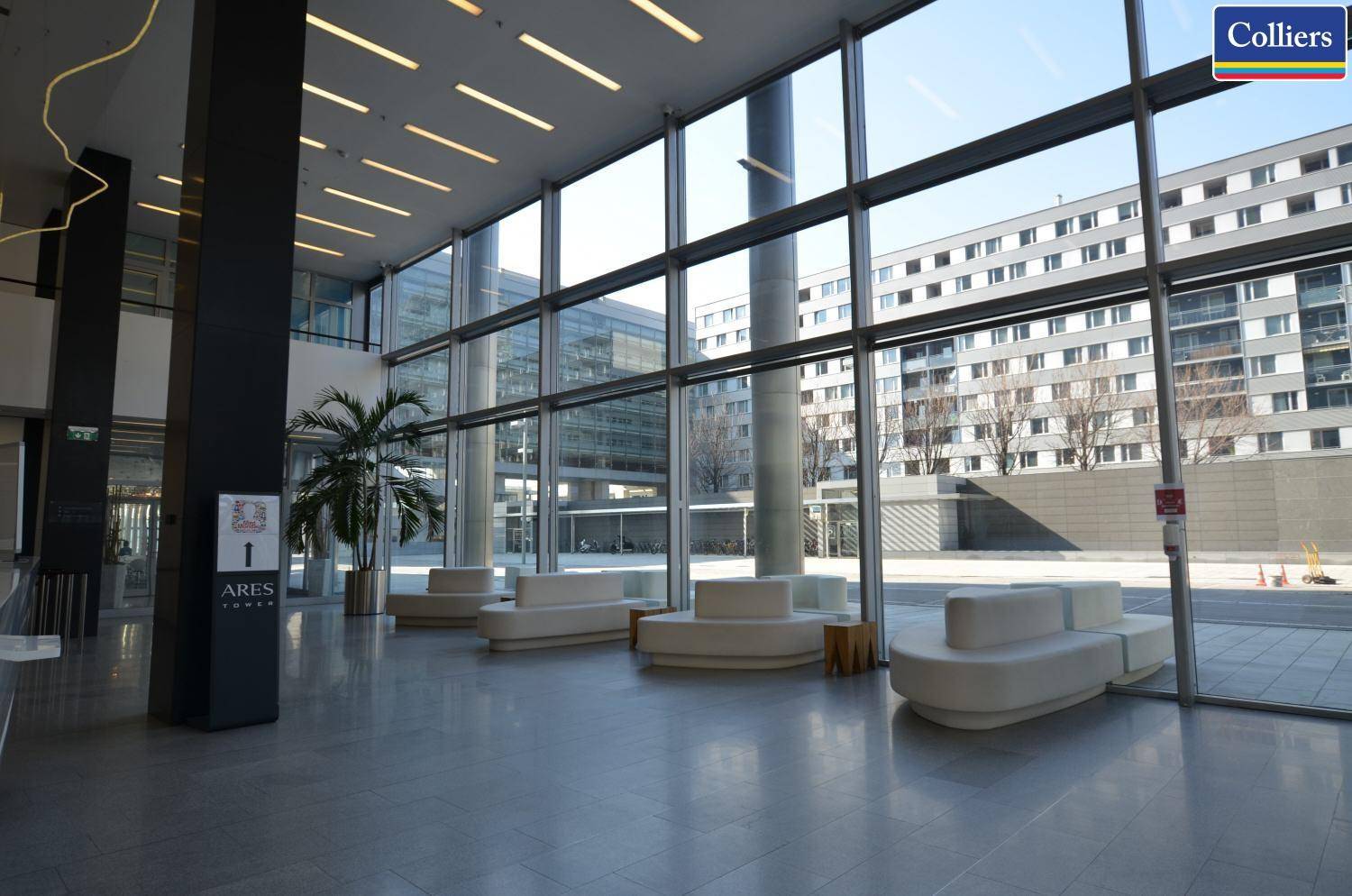 Großzügige Lobby mit hohen Glasfassaden, bequemen Sitzgelegenheiten und viel Tageslicht.