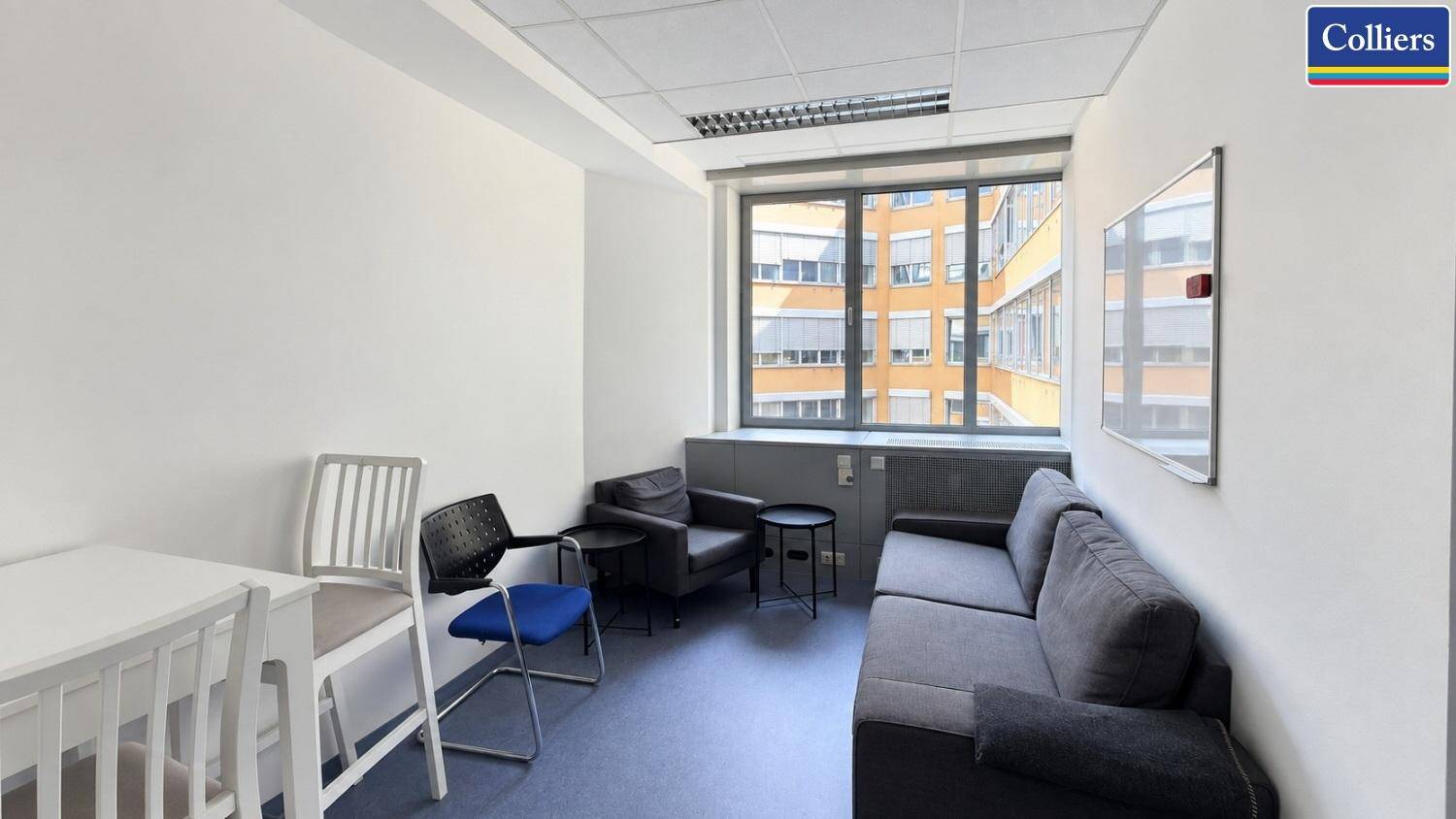 Gemütlicher Aufenthaltsraum mit Sofa, Sesseln und einem Fenster mit Blick auf die Nachbarschaft.
