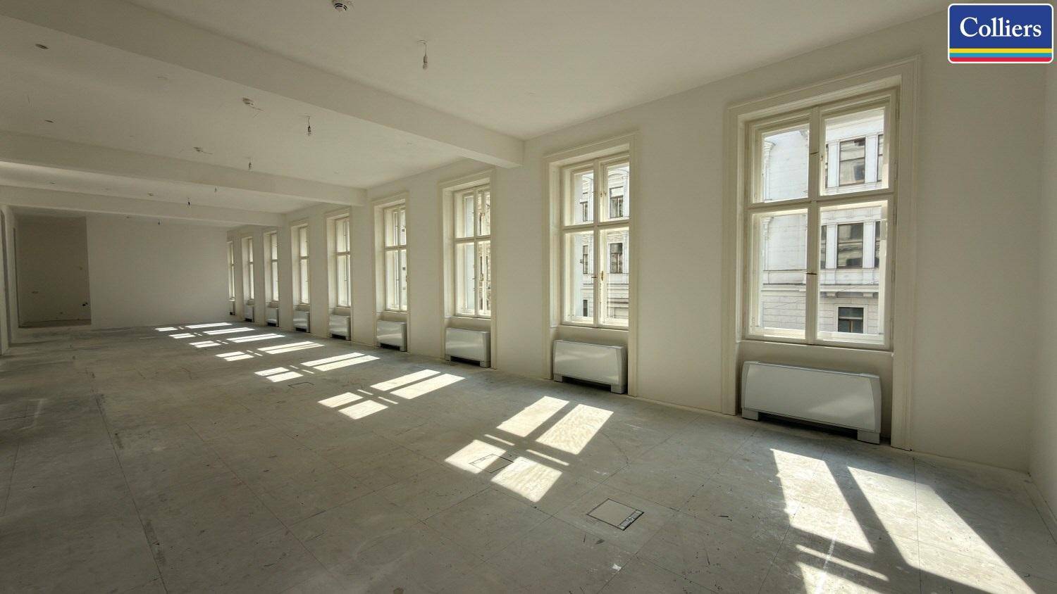 Großer, offener Bürobereich mit zahlreichen Fenstern, die viel Tageslicht hereinlassen.