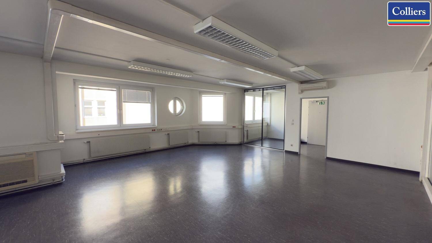 Großes, leeres Büro mit Spiegelschränken und Zugang zu weiteren Räumen, bietet flexible Nutzungsmöglichkeiten.