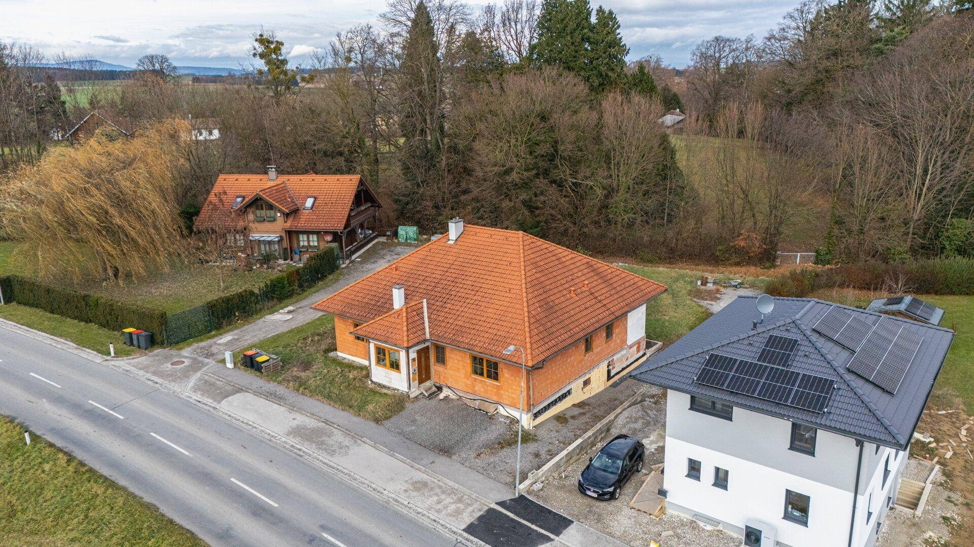 Luftaufnahme eines Hauses mit Ziegeldach und Solaranlage auf dem Nachbargebäude.