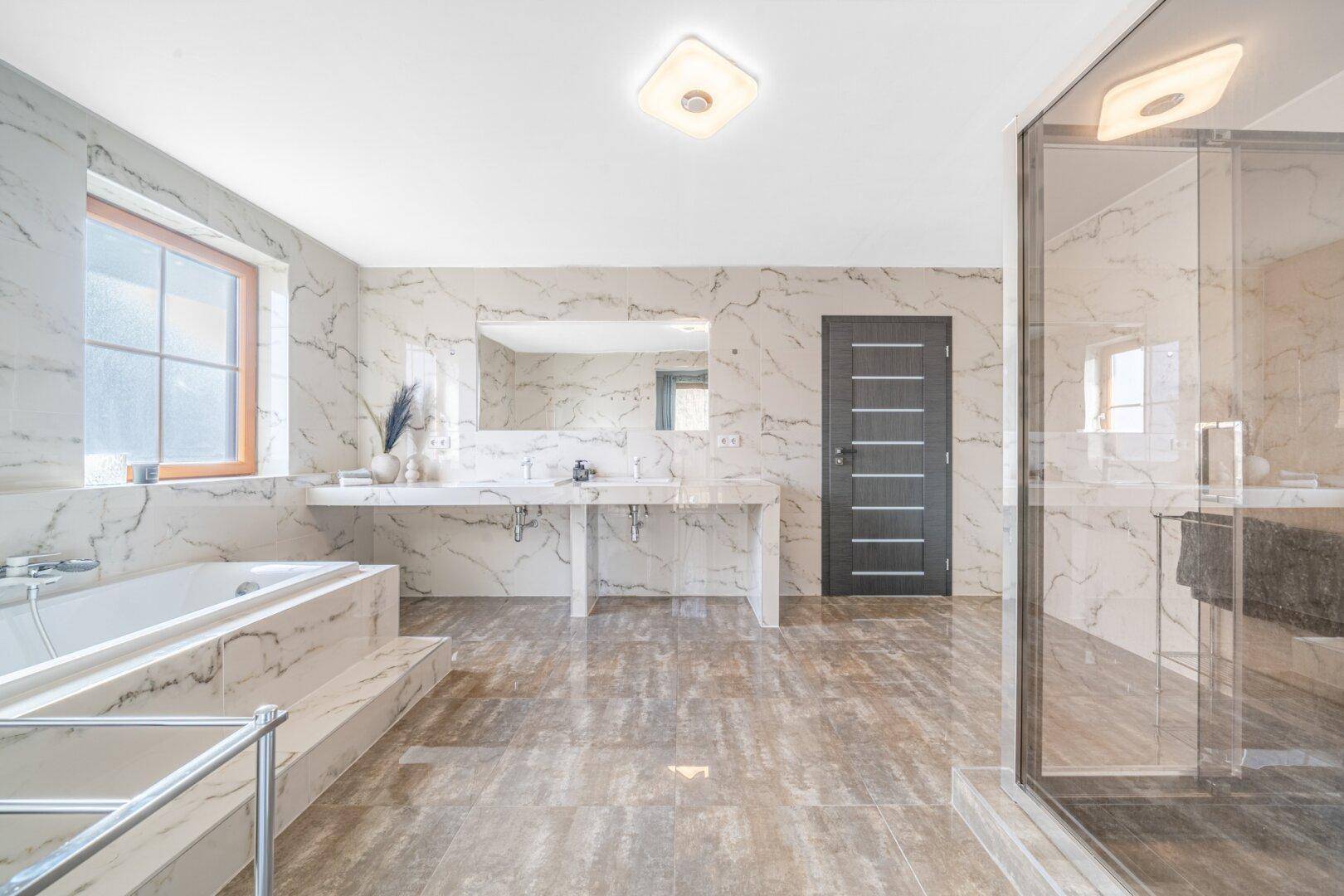 Großes, helles Badezimmer mit Doppelwaschbecken, Badewanne und begehbarer Dusche.