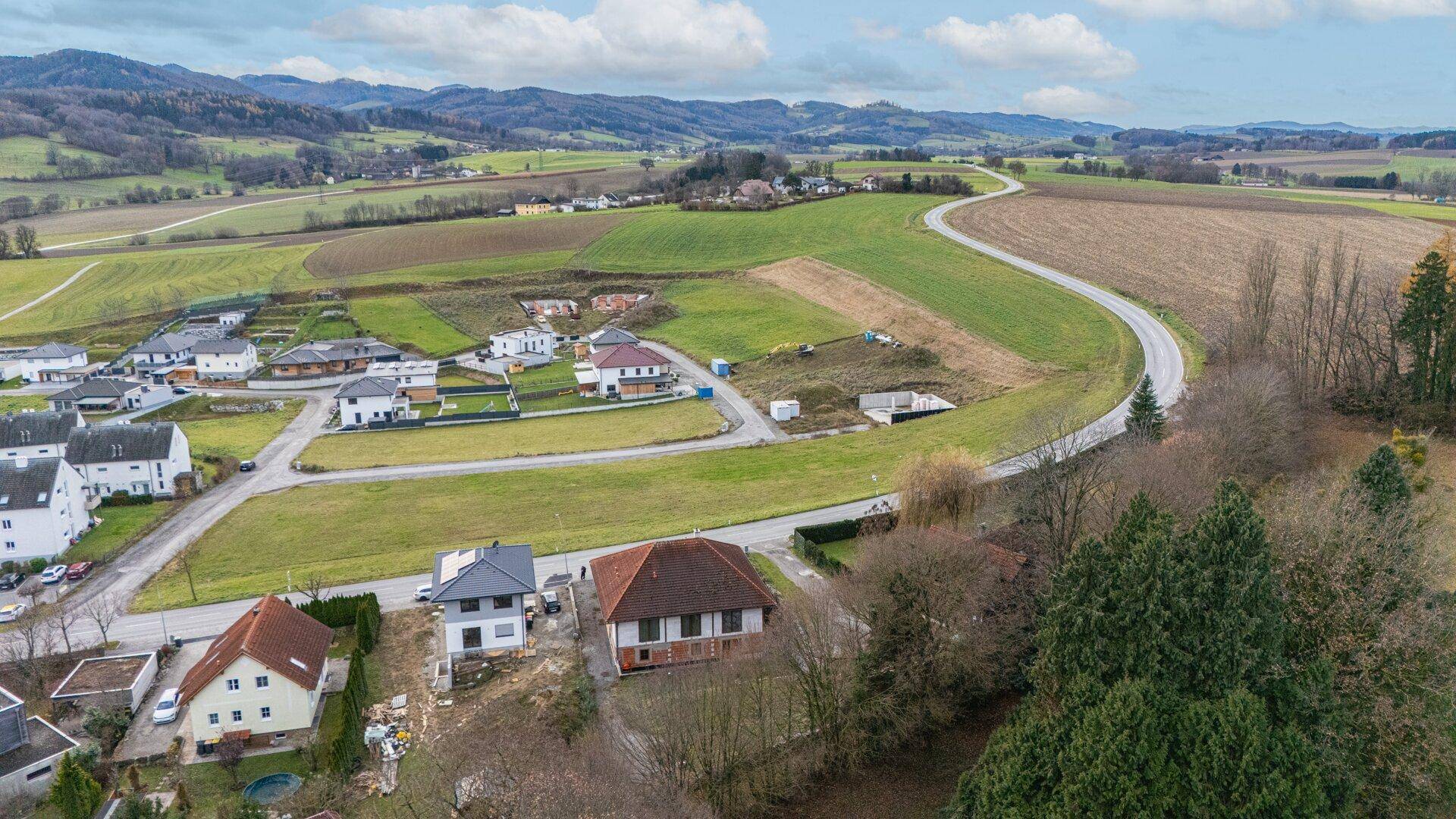 Weitläufige Landschaft mit Wohngebieten, Feldern und Straßen.