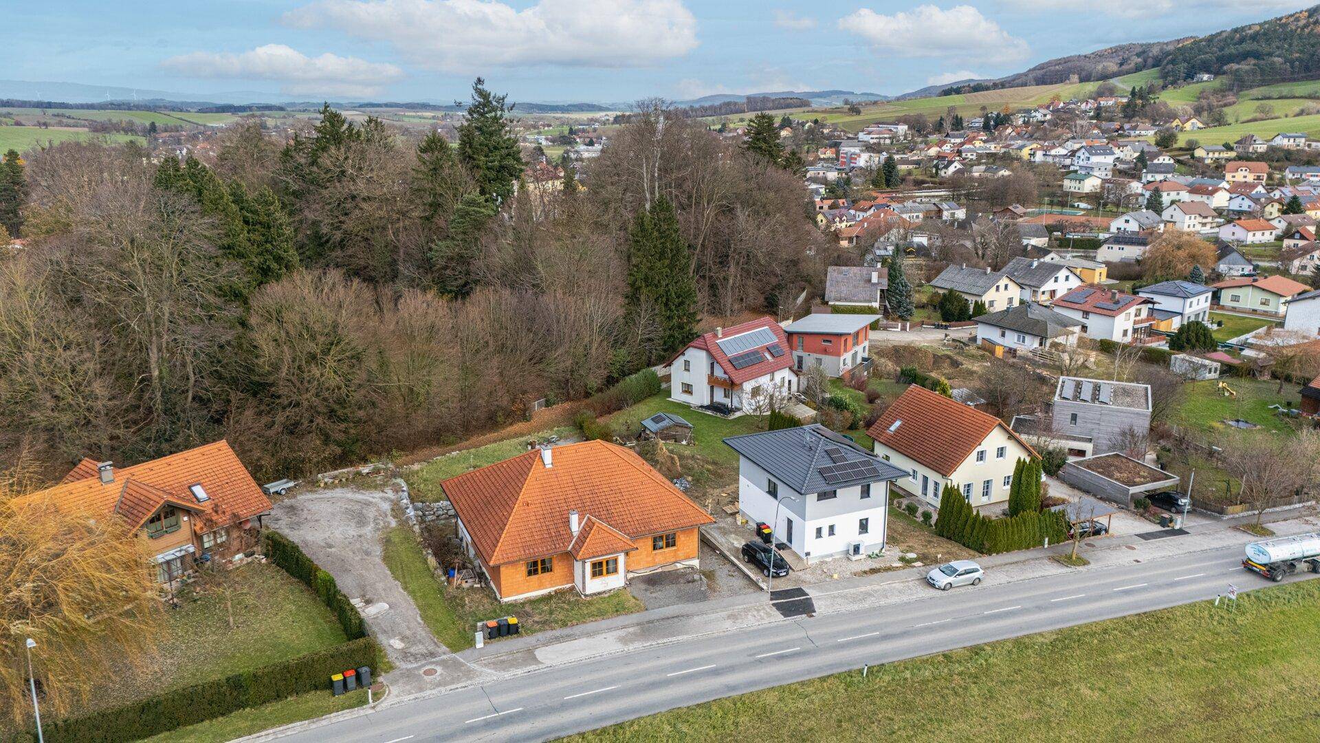 Luftaufnahme einer Wohnsiedlung mit Häusern und grüner Landschaft.
