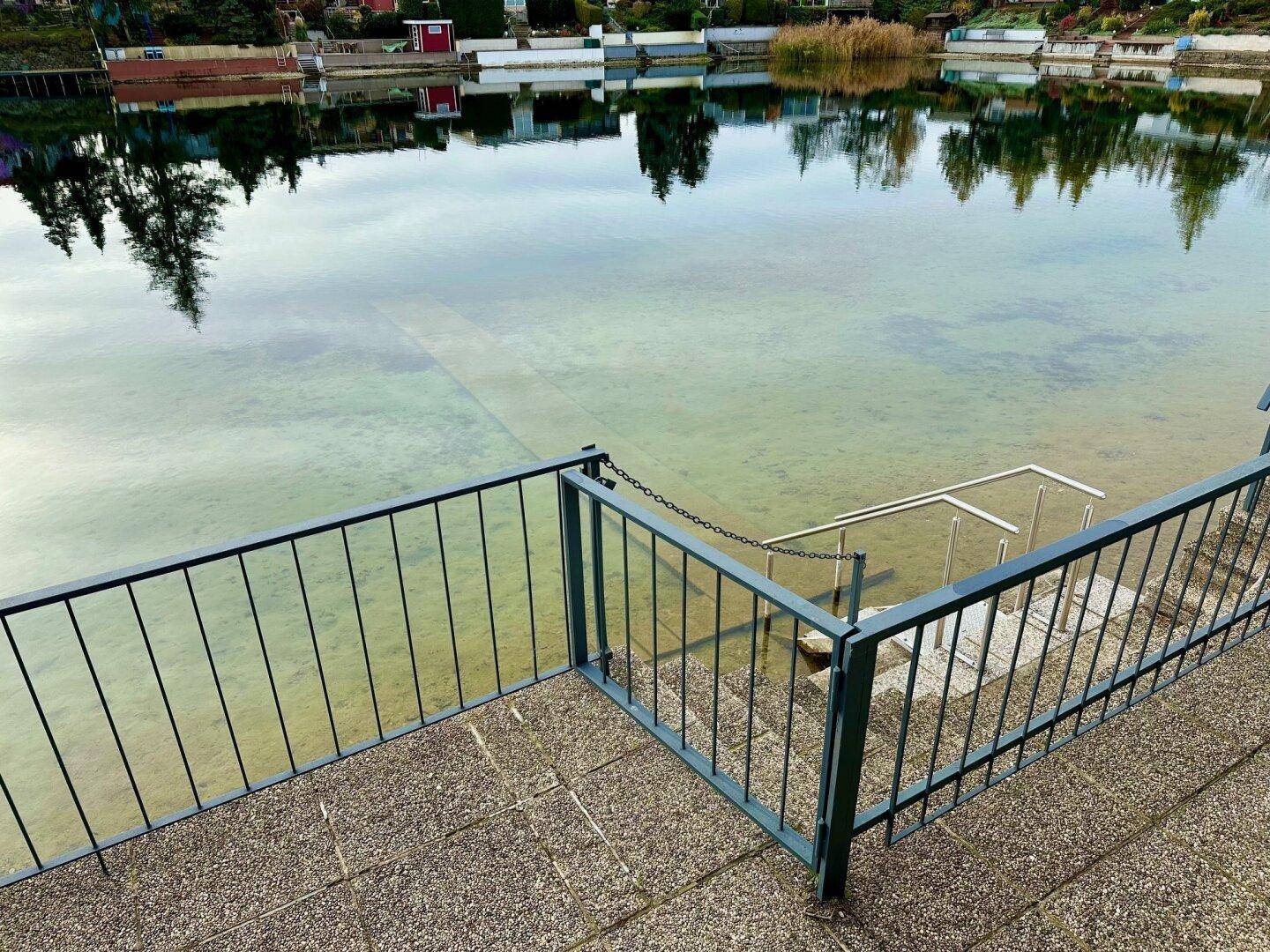 Treppe mit Geländer führt direkt ins klare Wasser des Sees, ideal zum Schwimmen.