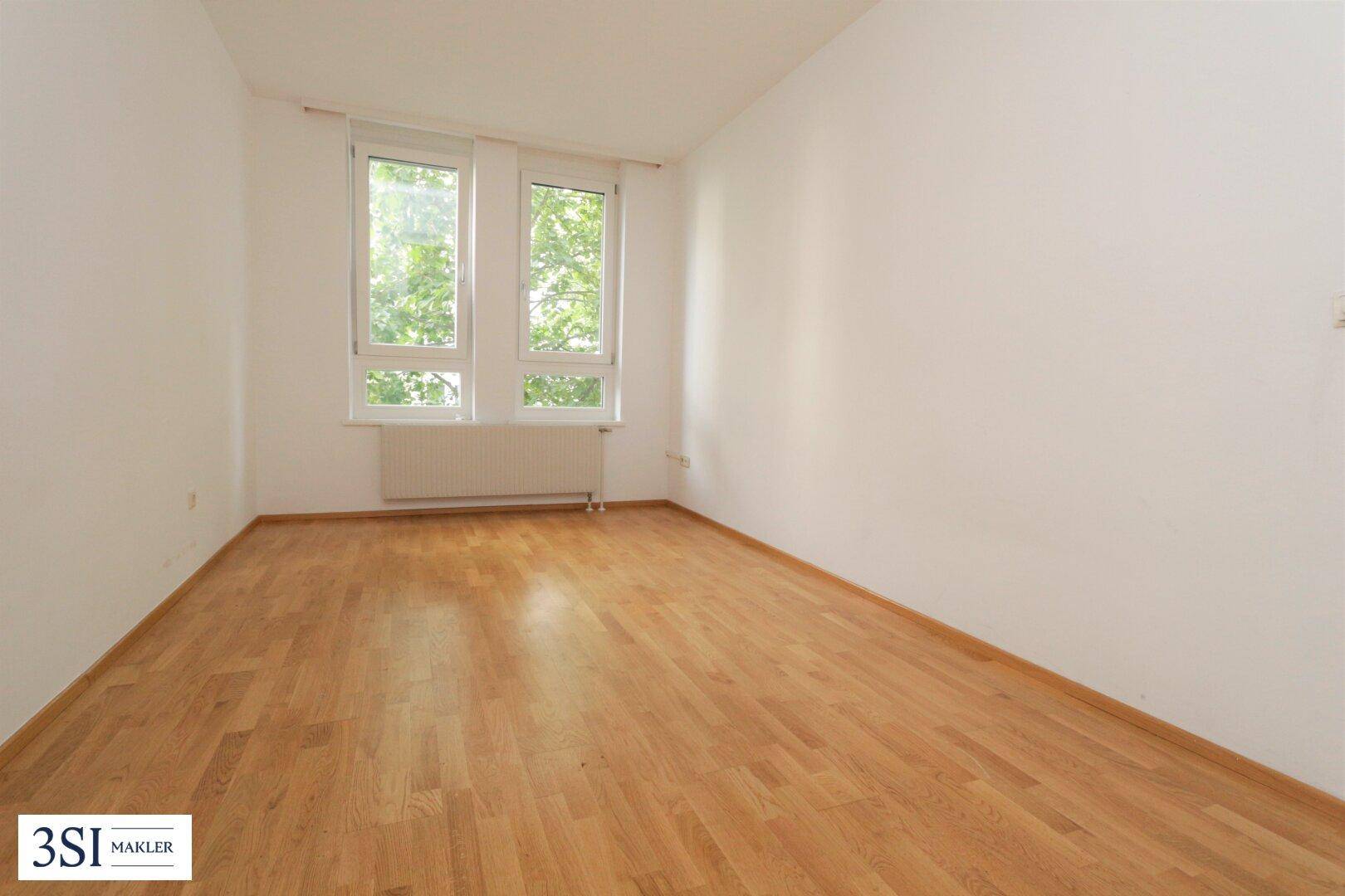 Weiteres helles Zimmer mit Parkettboden und weißen Wänden, ideal als Schlaf- oder Arbeitszimmer nutzbar.