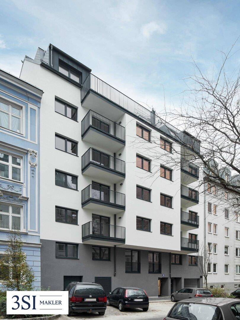 Moderne Wohnfassade mit mehreren Balkonen und großen Fenstern in städtischer Umgebung.