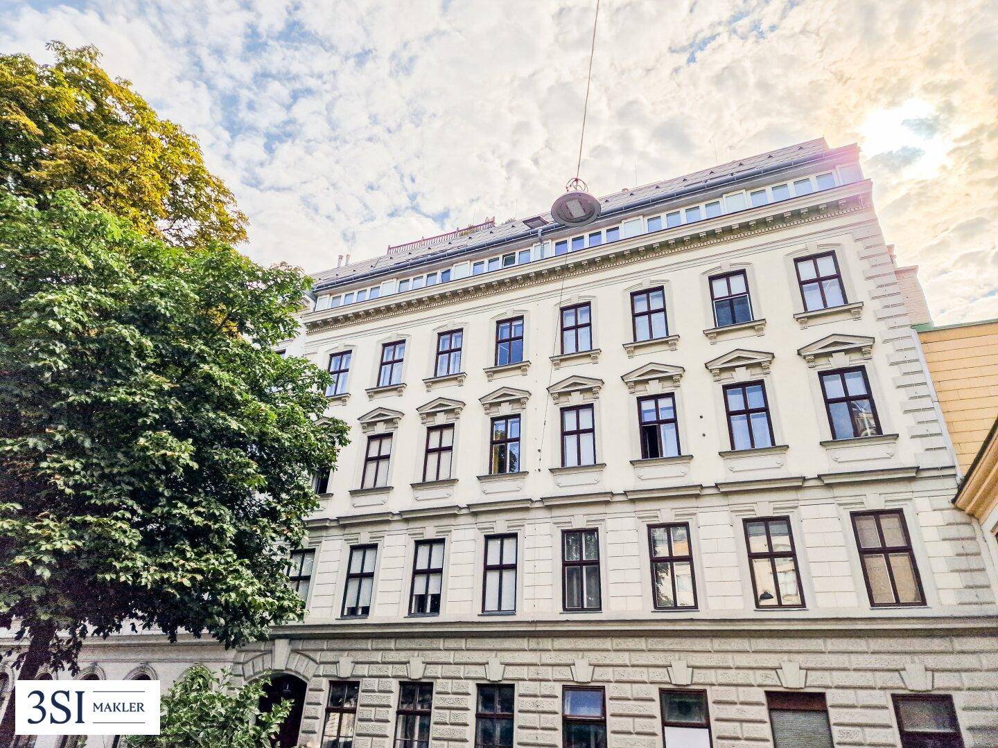 Historische Fassade eines Altbaus mit vielen Fenstern und klassischer Architektur.