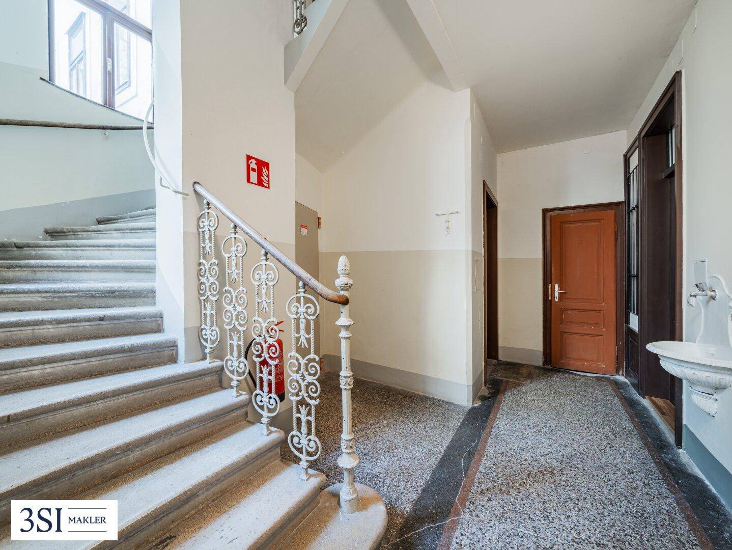 Historisches Treppenhaus mit Steinstufen und kunstvollem Geländer in einem gut erhaltenen Altbau.