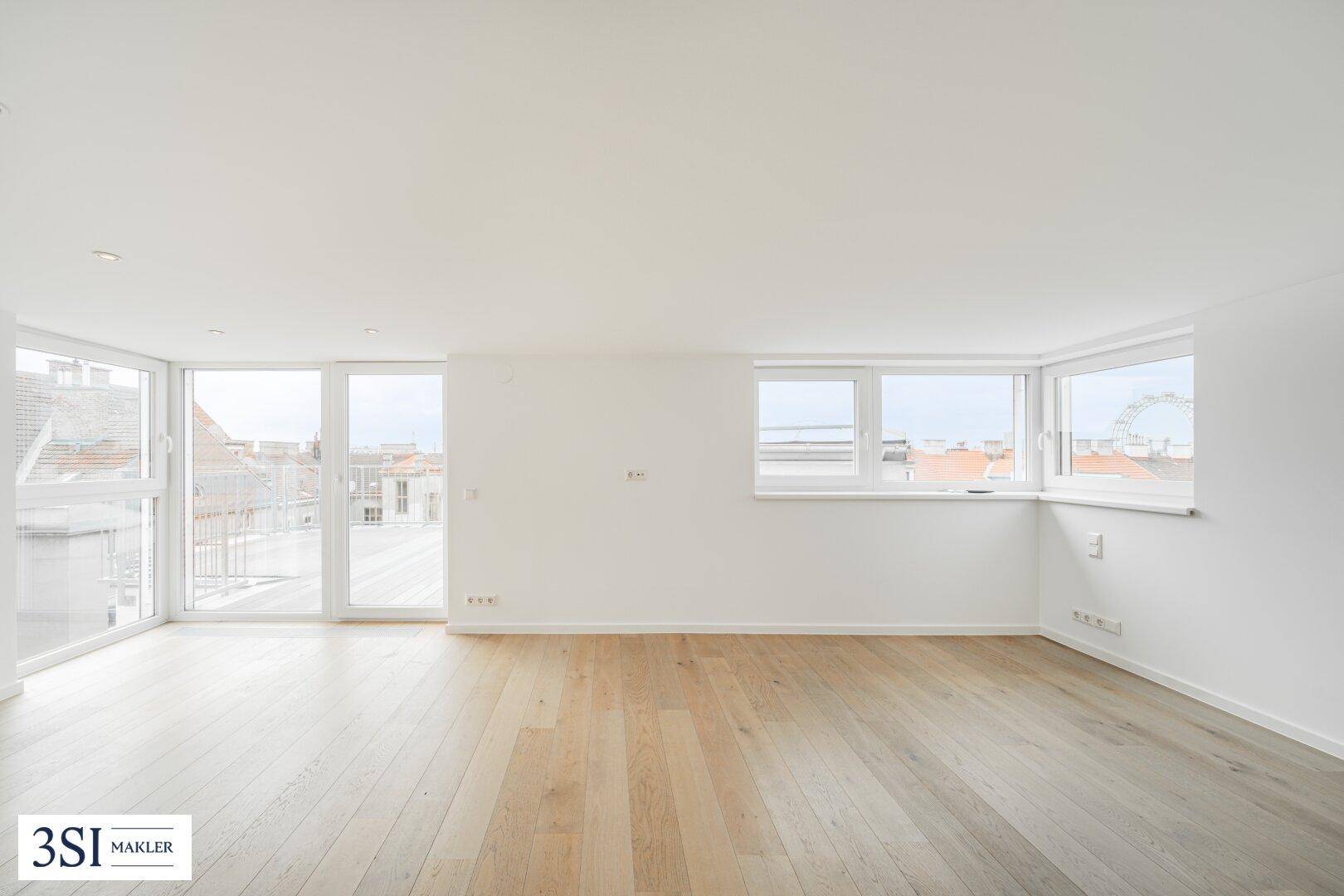 Geräumiger Wohnbereich mit Holzboden, großen Fenstern und Zugang zu einer Dachterrasse.