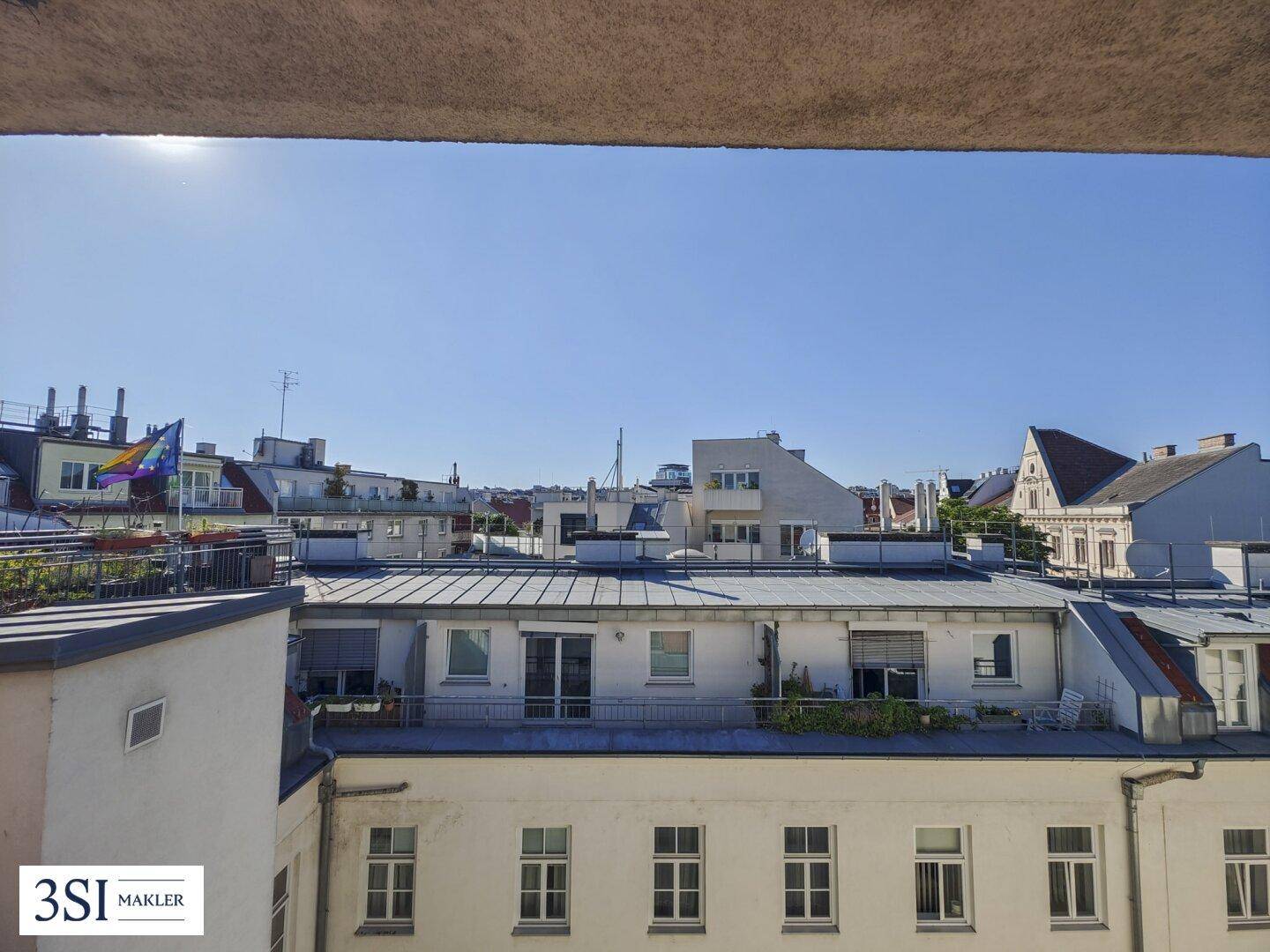 Weitblick über die Dächer der Stadt und umliegende Gebäude an einem klaren Sommertag.