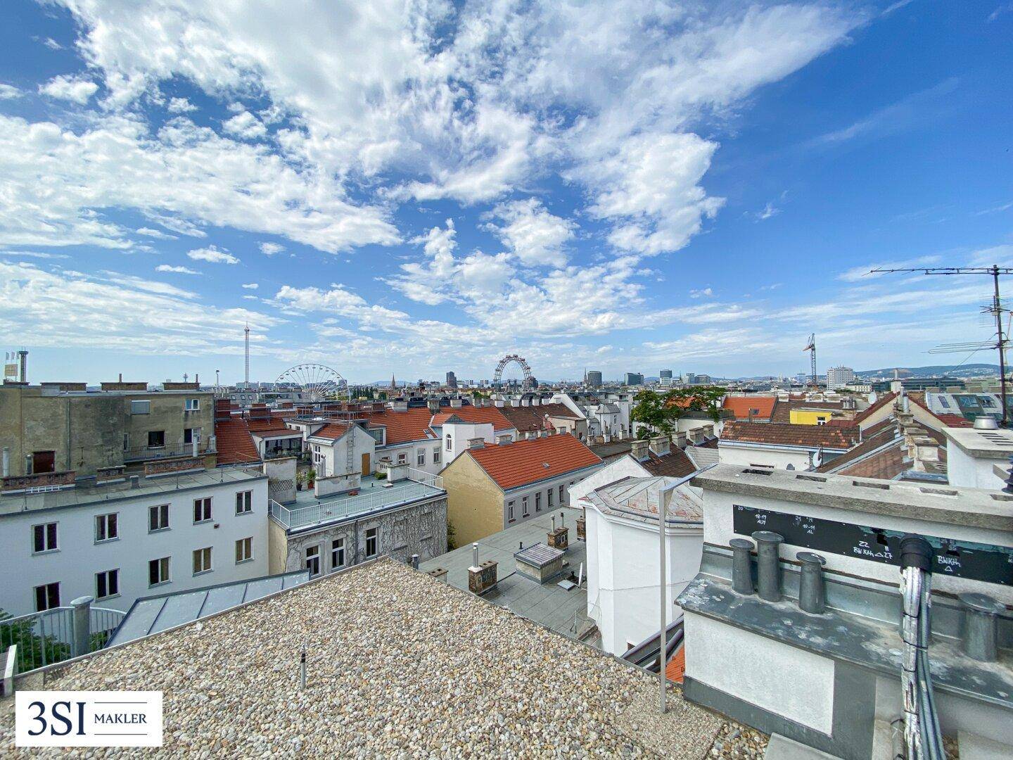 Weitläufiger Blick über die Dächer der Stadt unter einem strahlend blauen Himmel.