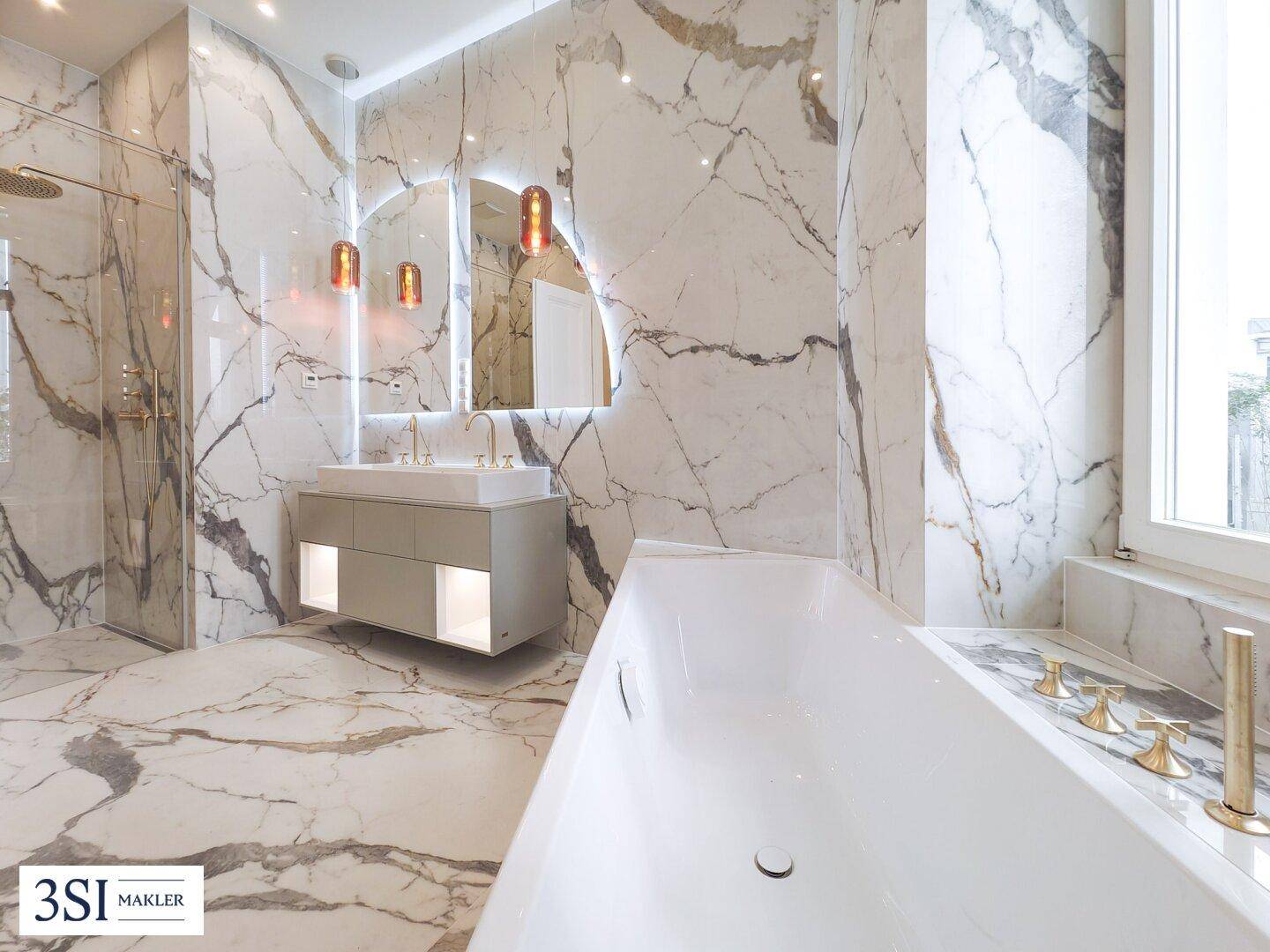 Luxuriöses Badezimmer mit großformatigen Marmorfliesen, moderner Badewanne und begehbarer Dusche.