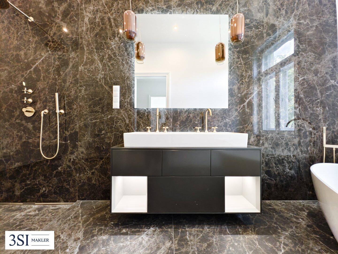 Elegantes Badezimmer mit dunklen Marmorwänden, Doppelwaschbecken und modernen Armaturen.