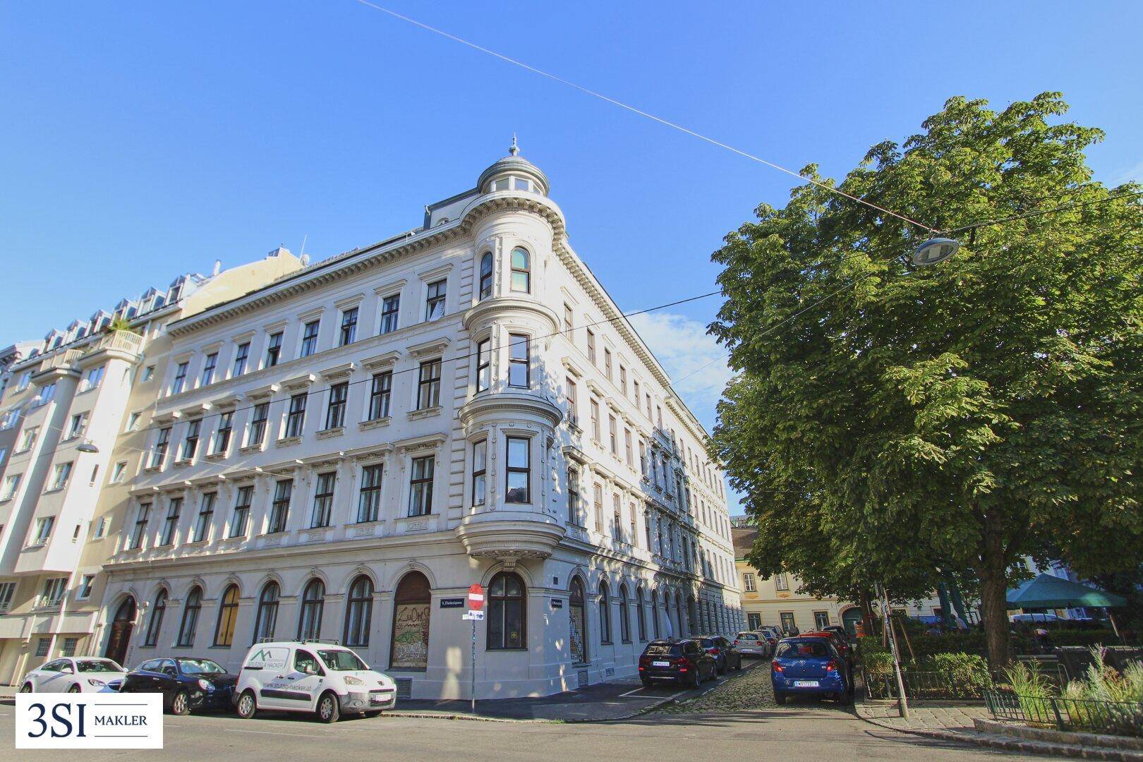 Historisches Eckgebäude mit eleganter Architektur und gepflegter Fassade an einer städtischen Straße.