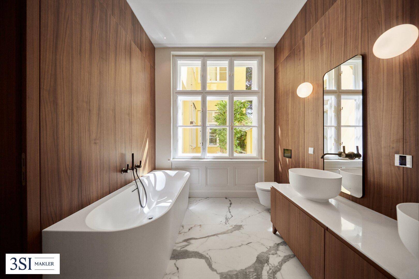 Modernes Badezimmer mit Holzverkleidung, freistehender Badewanne und Marmorboden.